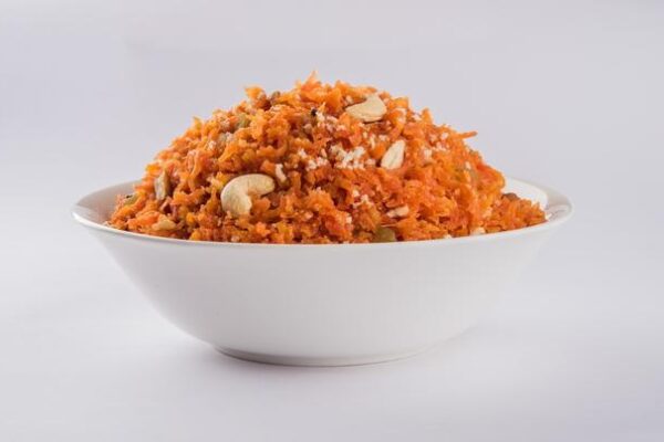 gajar-halwa-is-carrot-based-sweet-dessert-pudding-from-india-garnished-with-cashew-almond-nuts-served-bowl-colourful-wood-background_466689-68588